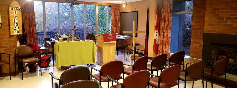 Chapel space with rows of chairs, a lectern, and a cross at the front, set up for worship and gatherings.