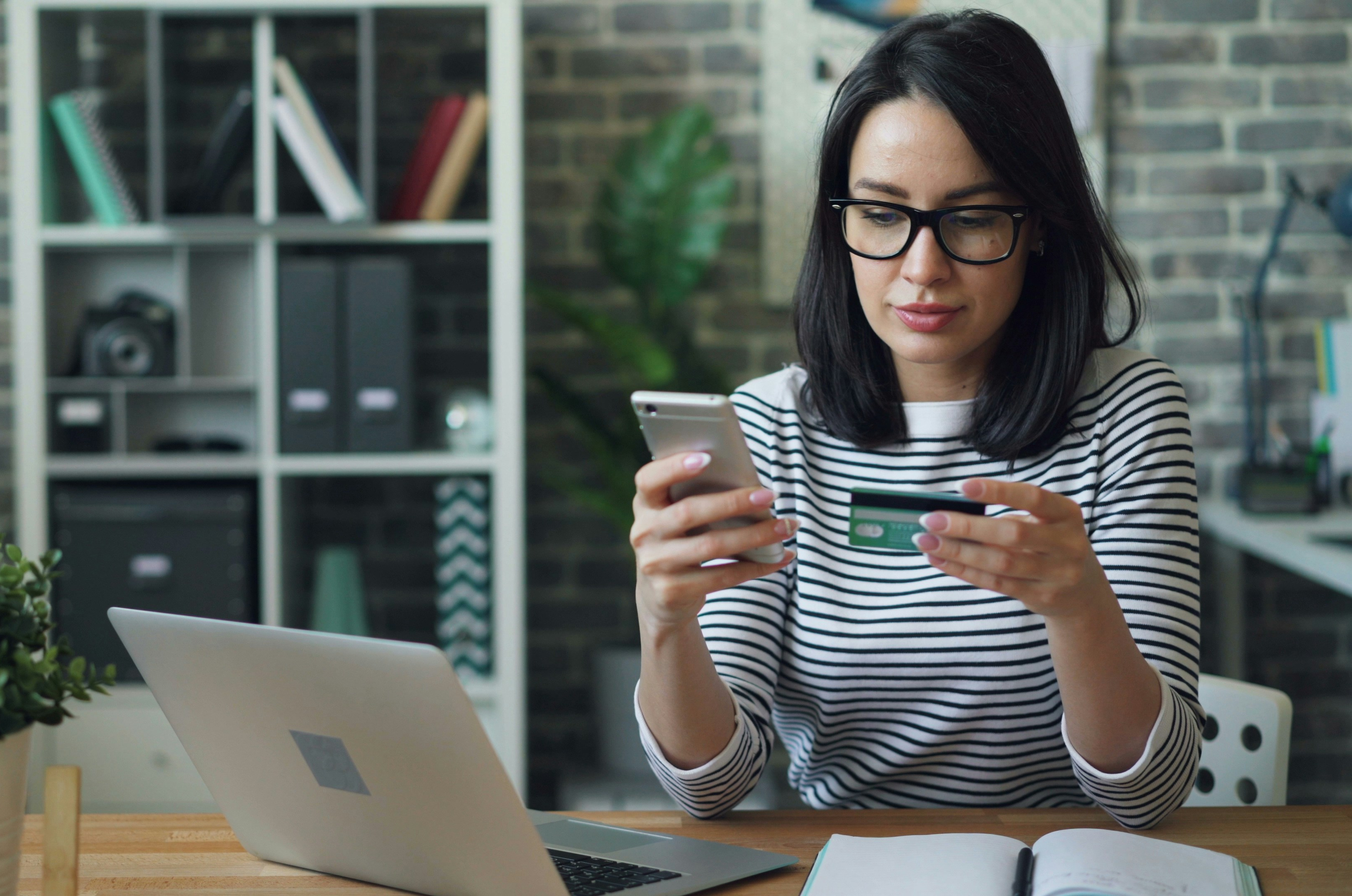 Person using a smartphone and credit card to make an online donation.
